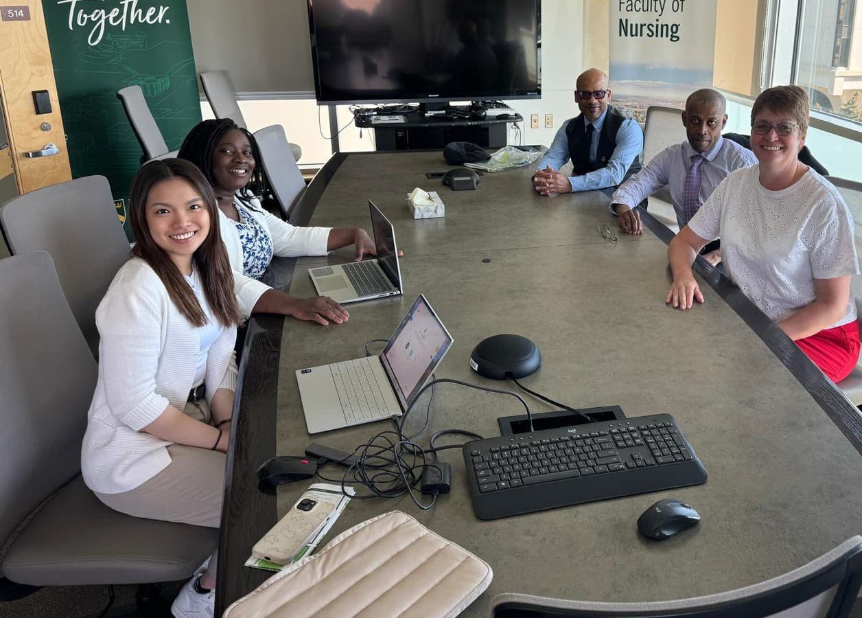 Older adults and researchers seated together around a meeting table